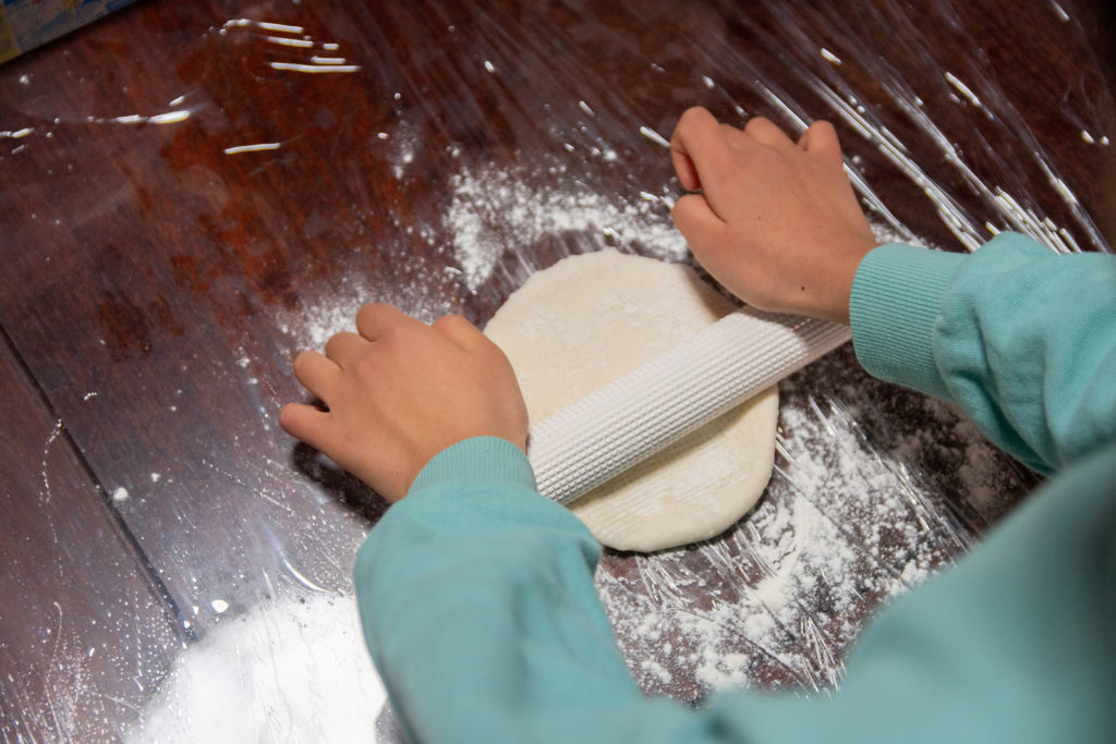 食育応援企画「野菜収穫とピザクッキング」でピザの生地を伸ばす